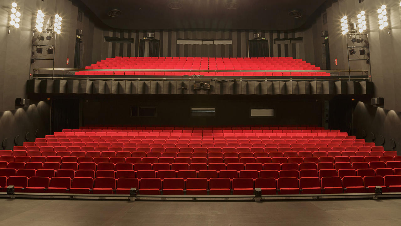 Pildil Endla Teatri suur saal punaste toolide ja mustade seintega. Mõlemal küljel on seintel kolm komplekti prožektoreid.