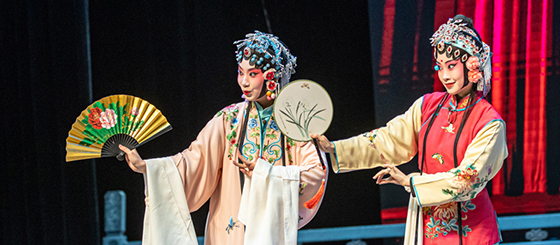 Pildil on kaks naisnäitlejat hiina ooperis. Neil on seljas värvilised pikkade varrukatega kleidid ning käes värvilised lehvikud.