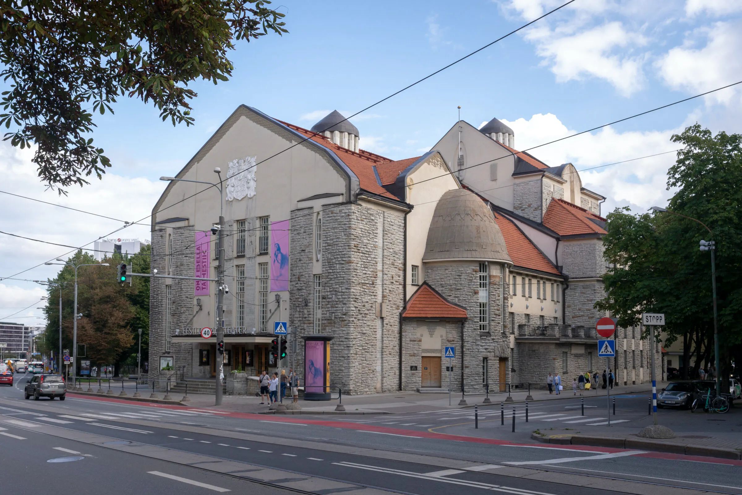 Pildil on Eesti Draamateatri hoone, mis asub Tallinna kesklinnas Pärnu maantee ääres. Tegu on ajaloolise hoonega, mille fassaad on osaliselt kivist laotud, osaliselt heledaks värvitud. Hoone katus on punast värvi.