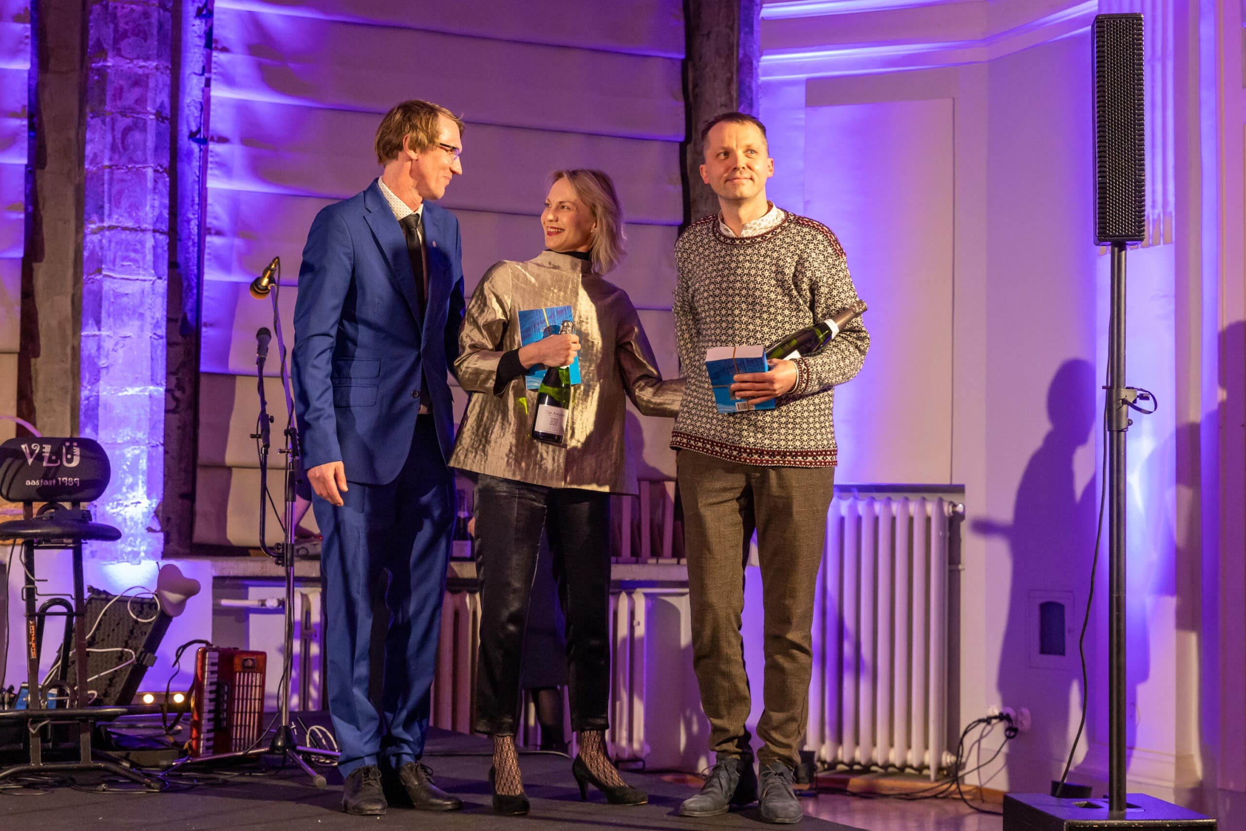 Pildil on koos Tallinna Linnateatri direktori Mihkel Kübaraga näitlejad Külli Teetamm ja Argo Aadli, kes on äsja preemiaks saanud raamatu ja pudeli vahuveini. Nad seisavad kõrvuti väikese lava peal.
