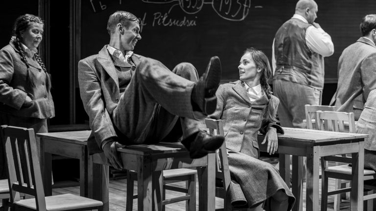 Pilidl on fookuses näitlejad Rait Õunapuu ja Klaudia Tiitsmaa, kes lavastuse "Meie klass" stseenis omavahel vestlevad. Õunapuu istub koolilaual, jalad õhku tõstetud, ja Tiitsmaa tema ees toolil. Taustal paistavad veel kolm näitlejat.