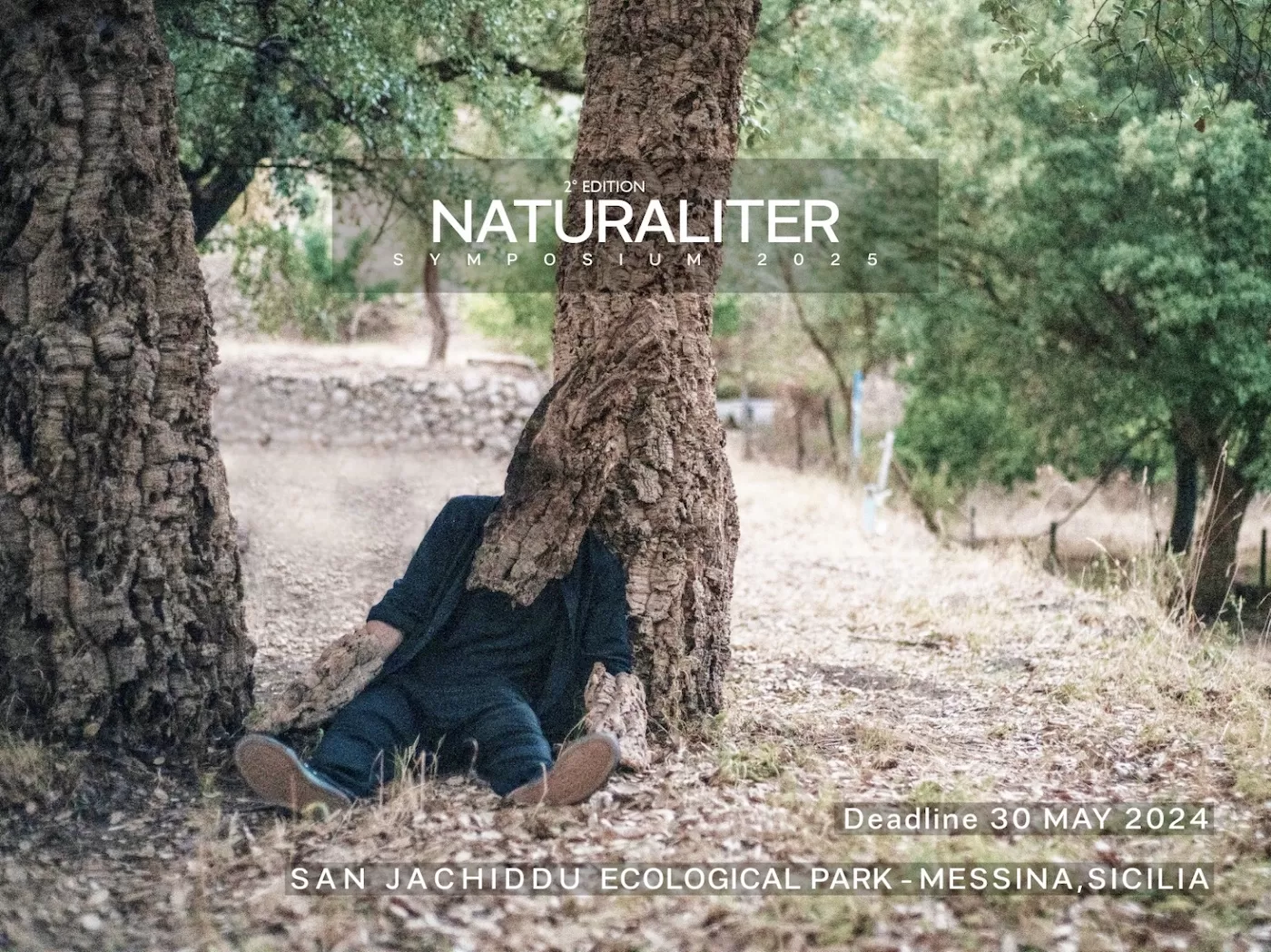 Pildil on inimene, kes istub puu all ja on osaliselt puukoorega kaetud, justkui oleks ta puuga kokku kasvanud. Pildi ülaosas on kirjas "NATURALITER Symposium 2025" ning allpool "Deadline 30 May 2024 / San Jachiddu Ecological Park - Messina, Sicilia".