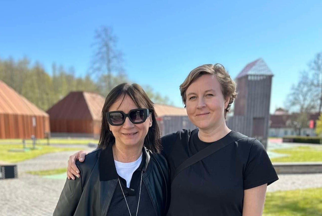 Pildil on Rosita Raud ja Laura Pählapuu, kes seisavad Ajaloomuuseumi hoovis Maarjamäel. Mõlemad vaatavad kaamerasse, Pählapuu toetab kätt Raua õlale.