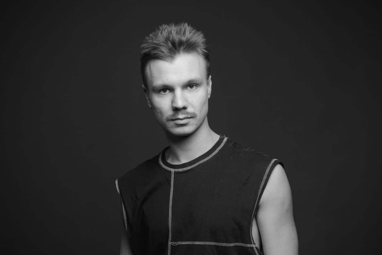 Mustvalgel pildil on Alex Paul Pukk, tal on lühikesed juuksed ja vuntsid. Ta kannab seljas tumedat ilma varrukateta särki.