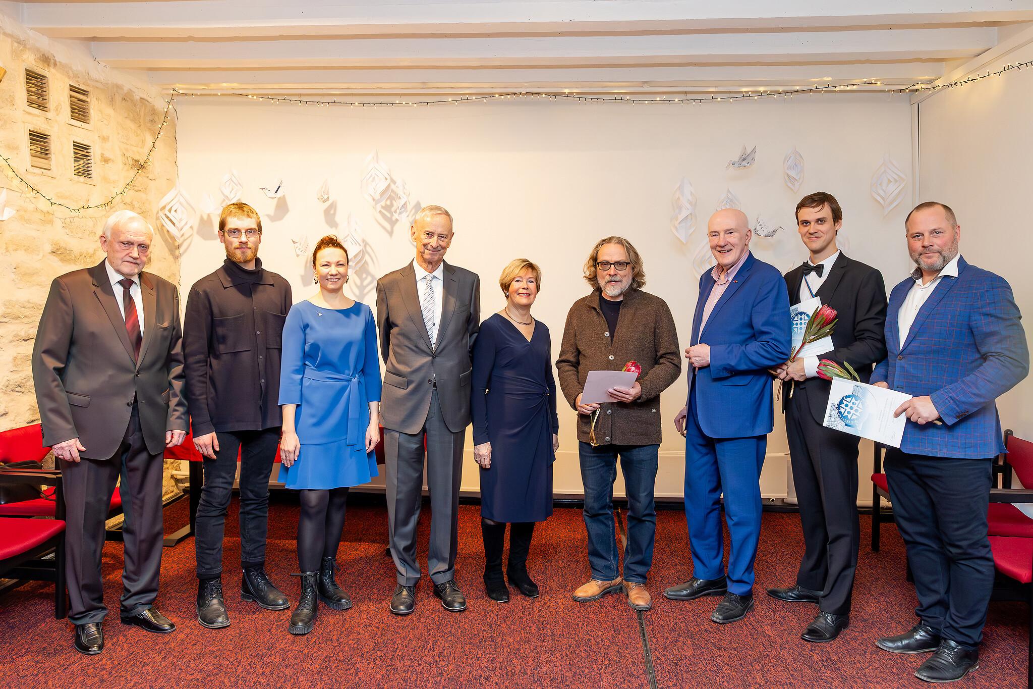 Pildil seisavad reas üheksa inimest, kellest kolm hoiavad käes ka diplomit. Nende taga paistab valge sein ja punase vaibaga põrand.
