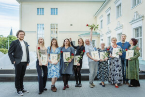 Pildil on kümme inimest, kes seisavad reas Estonia teatri rõdul. Neil on käes raamitud diplomid ja punased roosid.