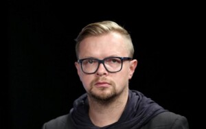 Esileht Portreepildil on Dmitri Petrenko, tal on lühikesed heledad juuksed ja lühike habe. Ta kannab tumedate raamidega prille.