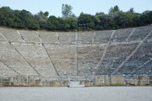 Esileht Pildil on näha Epidauruse antiikteatrit ehk ajaloolist etenduspaika, mille publikuala on poolkaares kivitrepistik. Trepistiku ees keskel on kruusane plats.