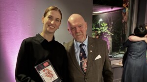Pildil seisavad kõrvuti Maria Seletskaja ja Graham Watts. Seletskaja hoiab käes diplomit.